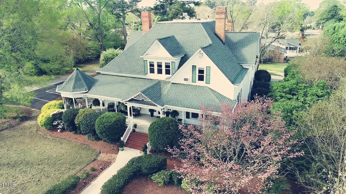 Aerial view of the Magnolia Inn estate — a Queen Anne home with wraparound porch and mature gardens